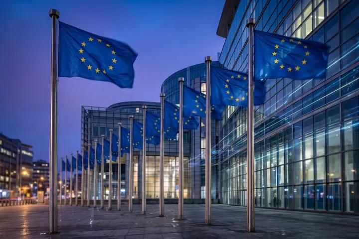 European Union flags in front of a glass building in Brussels