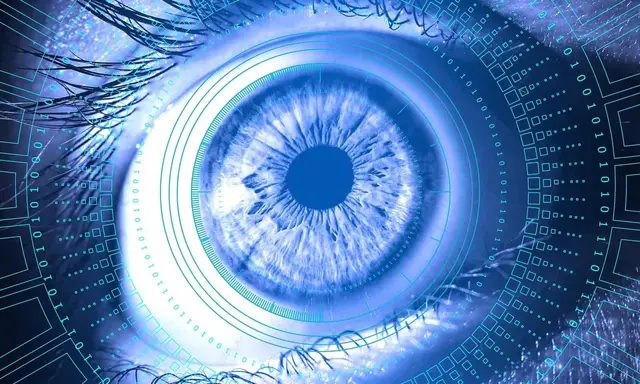 Close-up of a blue eye surrounded by concentric circles and binary digits, suggesting machine vision