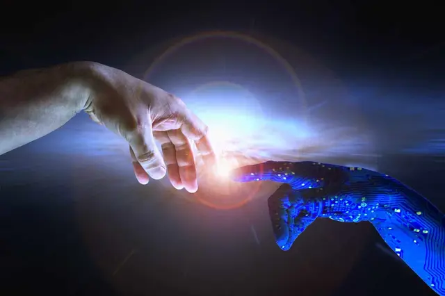 A human hand and a blue robotic hand with circuitry reach toward each other, with a flash of light between them on a dark background