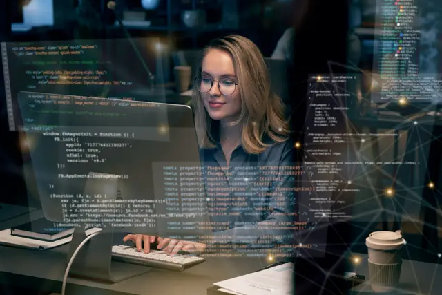 A developer wearing glasses smiles in front of a screen of code, surrounded by overlaid lines of programming and connected dots.