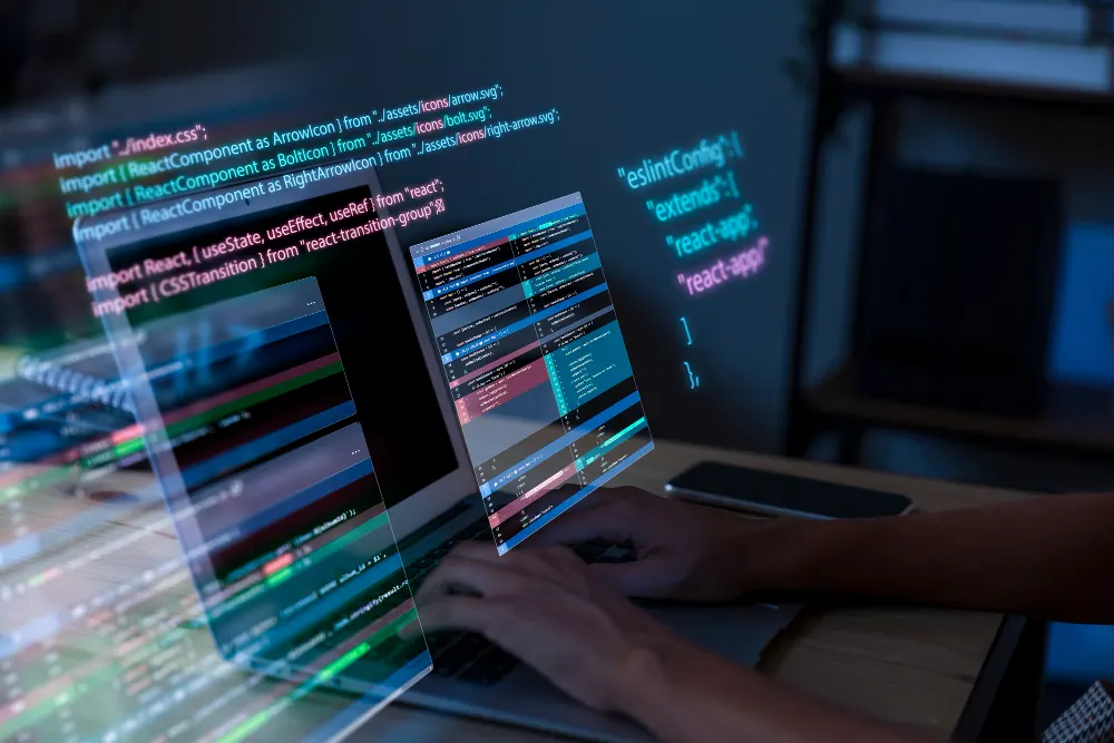 Hands typing on a laptop while lines of colorful code overlap the screen, an image of software development work