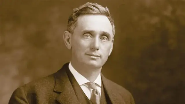 Sepia portrait of a short-haired man in a dark suit, white shirt and tie, an image of Judge Louis Brandeis